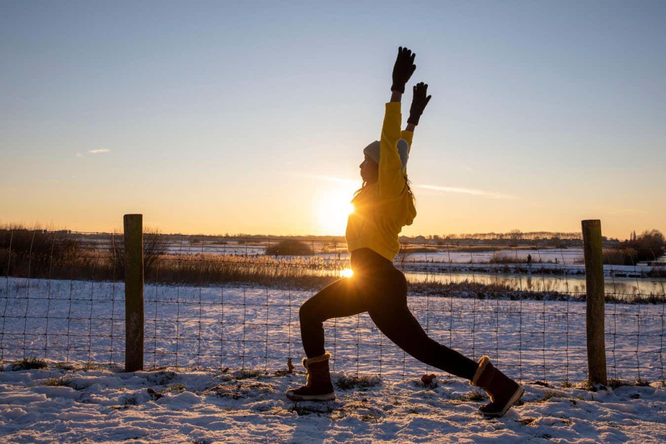 2G4X5CY Mature woman with arms raised doing stretching exercise during winter