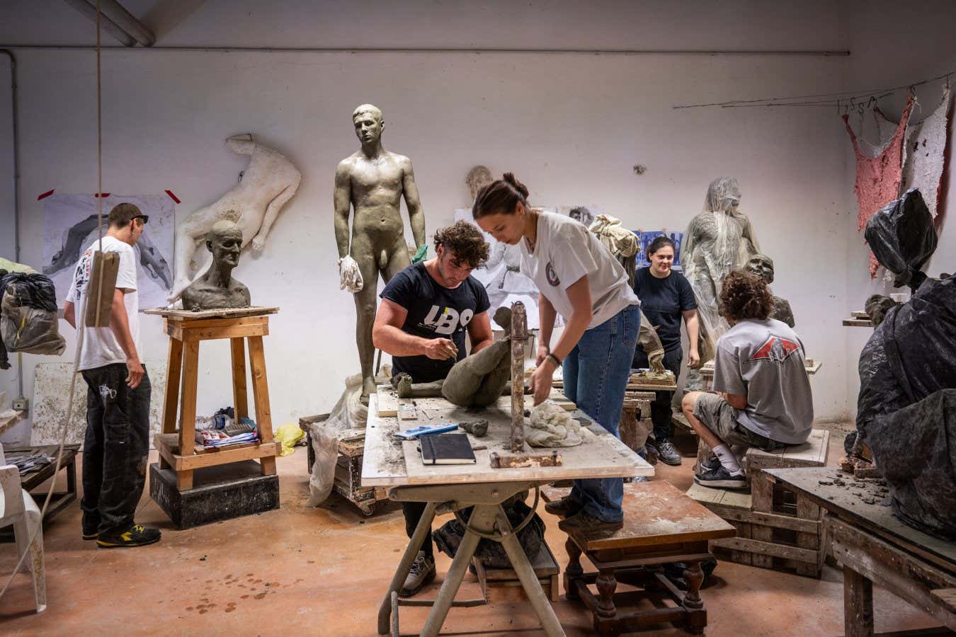 Sculpture students work on clay models at the Academy of Fine Arts.