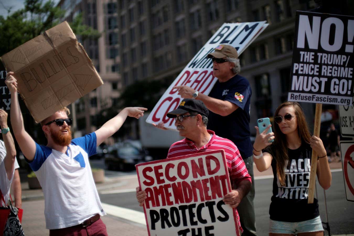 Paul Jutte (L) and Alexa Johnson (R) of Cincinnati, Ohio, counter a counter-protest of a Women's March rally against the National Rifle Association by conservative gun rights activists on Pennsylvania Avenue outside the Department of Justice in Washington, U.S., July 15, 2017. REUTERS/James Lawler Duggan